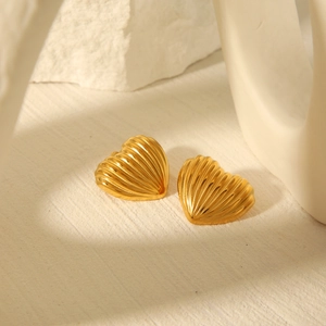 Detail of 18k gold heart stud earrings featuring a distinct linear striped texture