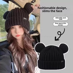 Detail of a black knit beanie with cute bear ears and a textured thick wool finish