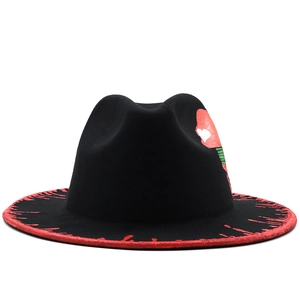 Détail du chapeau fedora noir en laine avec bord aux éclaboussures rouges et art graphique