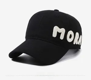 Detail showing white MORA embroidery on black cotton twill baseball cap side