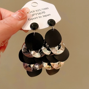 Detail of layered matte black and silver discs on 925 silver long drop earrings