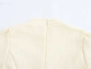 Detail van tweed stoftextuur en verborgen rits aan de achterkant van de jurk