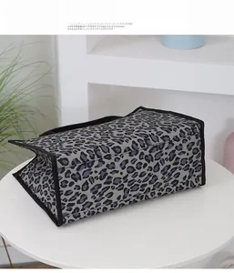 Detail view of stylish leopard print tote bag placed on a minimalist white table