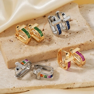 Elegant U-shaped hoop earrings with baguette-cut gemstones on premium marble surface