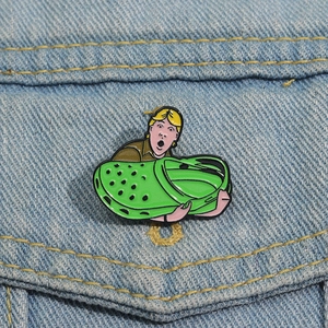 Detail einer grünen Slipper-Emaille-Anstecknadel an einer Denim-Jackentasche