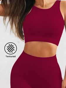 Detailed macro view of textured burgundy seamless knit sports bra and high-waist shorts set