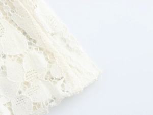 Close-up of intricate white floral lace fabric on a French style slimming bodycon dress