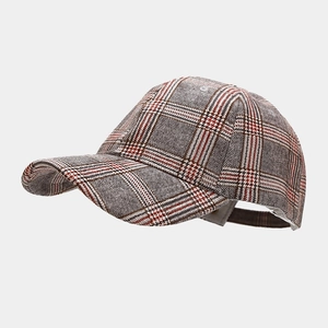 Detailed close-up of a classic plaid baseball cap with a textured tartan wool fabric