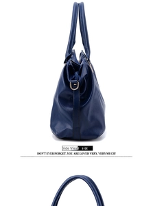 Detailed side view of navy blue lychee grain leather tote with golden D-ring hardware
