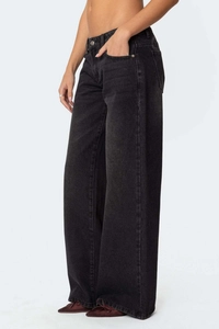 Vue latérale d'un jean noir taille haute à jambes larges avec texture denim délavée chic