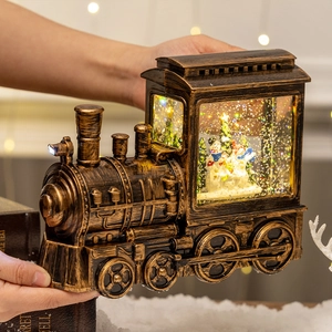 Vintage bronze Christmas train snow globe with glowing light and snowman interior