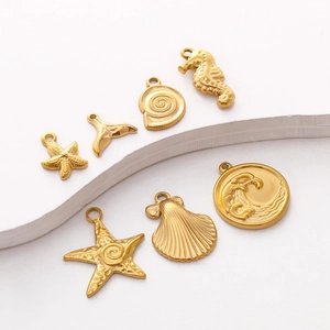 Golden stainless steel ocean pendants featuring starfish, shell and seahorse on white background