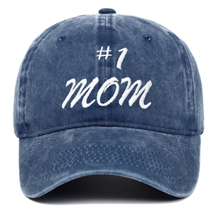 Detail of white #1 MOM embroidery on vintage washed navy blue denim baseball cap texture