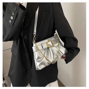 Détail du sac à main plissé argenté avec boucle carrée dorée texturée et chaîne