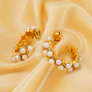 Elegant C-shaped gold pearl stud earrings with zircons on champagne silk background