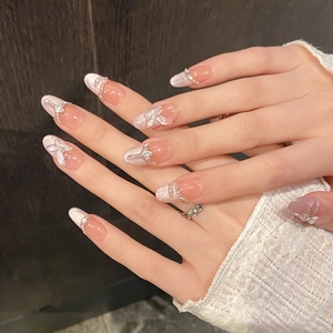 Sparkly butterfly press-on nails in nude pink with 3D crystal accents and pearls