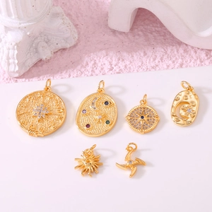 Set of six gold celestial pendants featuring moon, sun, and compass designs with zircons