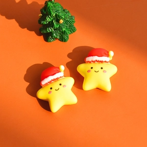 Close-up of yellow resin star figurines with mini red Santa hats for DIY hair clips
