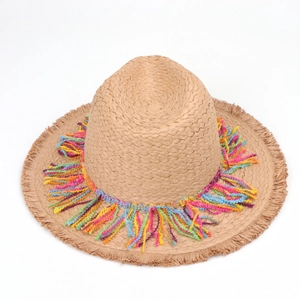 Detailed macro view of vibrant colorful tassels and woven texture on summer straw hat