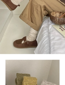 Close-up of beige wool knit socks paired with brown Mary Jane shoes in soft lighting