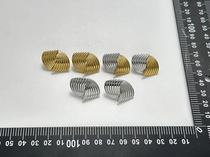 Detailvergleich von spiralförmig gestreiften Ohrsteckern in Gold, Silber und Bicolor-Optik