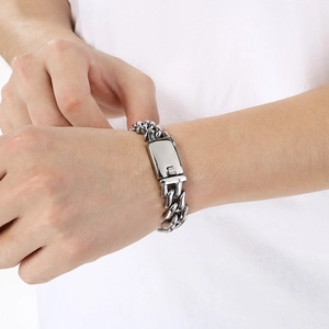 Macro detail of 15mm silver stainless steel Cuban link bracelet with rectangle clasp