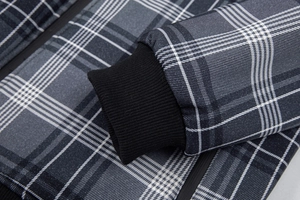 Detailaufnahme der grauen Karo-Baumwolljacke mit schwarzen Rippbündchen und Reißverschluss