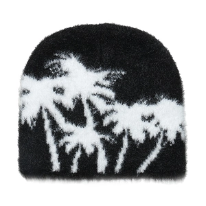 Detailed view of the fuzzy black knit beanie featuring a white palm tree jacquard pattern