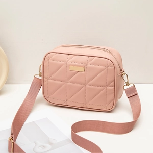 Pink quilted crossbody bag with stylish wide strap and gold hardware on white surface