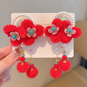 Detail of red plush flower earrings with pearls and soft tassels for girls
