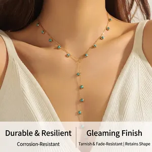 Detailed view of a gold Y-shaped tassel necklace with turquoise beads on a model