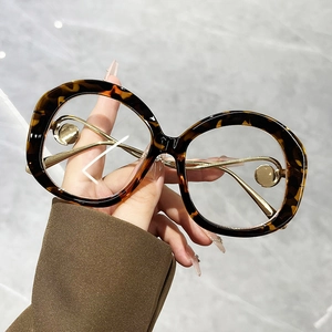 Detail of round tortoiseshell frame sunglasses with elegant gold metal temple accents
