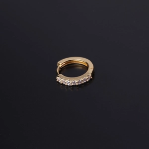 Detail of a gold huggie earring with seven round clear zircons in a claw setting