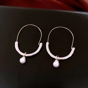 Detailed macro view of retro tiger eye pearl earrings with gold and silver hooks
