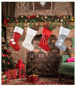 Détail de quatre chaussettes de Noël en tricot avec bordure en fourrure sur une cheminée