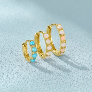 Macro view of gold plated S925 silver hoop earrings featuring blue and white opal stones