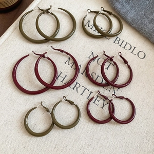 Detail view of geometric hoop earrings in deep green and burgundy resin finish