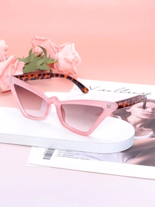 Detail of pink cat-eye sunglasses with tortoiseshell temples on a stylish prop display