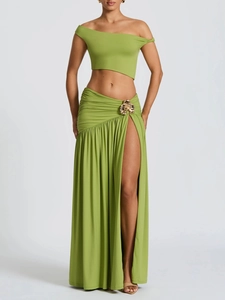 Detail of green ruched maxi skirt featuring an elegant gold flower metal waist buckle