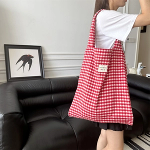 Detail shot of the red and white plaid tote bag featuring the sozakka beauté brand label