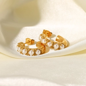 Elegant 18K gold-plated stainless steel C-shaped earrings with white pearls on silk background