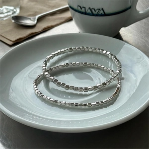 Minimalist S925 sterling silver beaded bracelet set shown on a white ceramic plate
