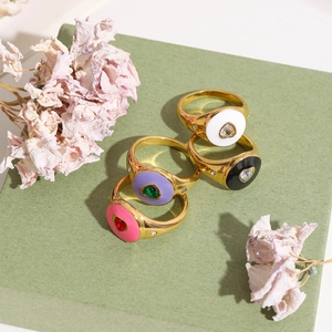 Detailed view of four gold-plated stainless steel rings with colorful enamel hearts