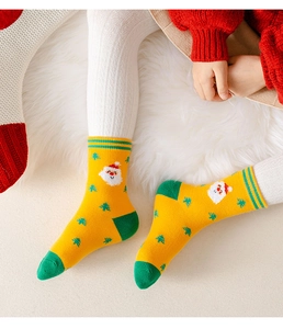 Dettaglio calzino natalizio giallo a maglia con Babbo Natale su tappeto di peluche