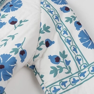 Détail de l'imprimé floral bleu sur tissu matelassé blanc avec coutures et texture