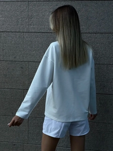 Vista posteriore di una t-shirt bianca in cotone a maniche lunghe e vestibilità