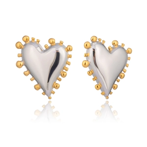 Détail de boucles d'oreilles cœur argentées avec accents dorés et design géométrique