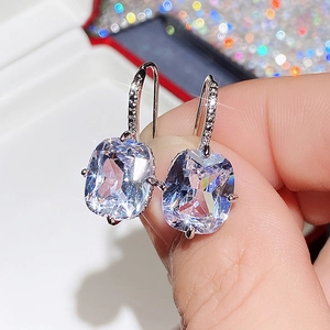 Close-up of elegant square-cut zircon earrings with silver hooks and micro-pave detailing