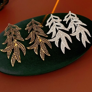 Detailed macro view of vintage leaf tassel earrings with sparkling rhinestones on velvet