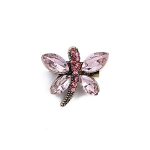 Detailed view of dragonfly brooch with pink marquise gemstones and crystals